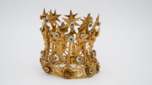 An early 20th century pierced gilt metal model of a crown with paste stones and a stylised floral