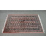 A rose ground handmade Pakistan Bokhara rug. L.150 W.100cm