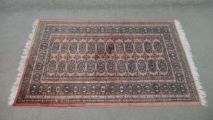 A rose ground handmade Pakistan Bokhara rug. L.150 W.100cm