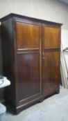 An Edwardian mahogany compactum wardrobe, with two panelled doors, enclosing a fitted and labelled
