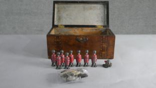 A marquetry inlaid box containing a collection of painted lead figures including a set of eight