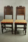 A pair of 17th century oak dining chairs with carved cresting above fielded panel backs on solid