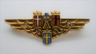 A Scandinavian Airlines 18 carat gold diamond and enamel brooch. The three country shields in