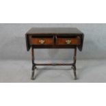 A George III style mahogany sofa table, with two drop leaves, two short drawers, on pierced end
