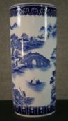 A 20th century blue and white Chinese porcelain stick stand decorated with a mountain landscape,