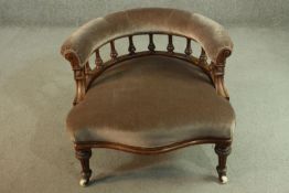A Victorian walnut salon chair, upholstered in brown velour, the curved back supported by turned
