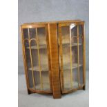 An Art Deco walnut bow front display cabinet, with two curved glazed doors, enclosing shelves,