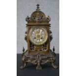 A 19th century bronze pierced foliate design mantle clock with gilt face and classical motifs, white