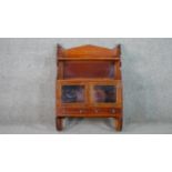 A late Victorian walnut wall mounted cabinet, with two shelves over two glazed cupboard doors. H.