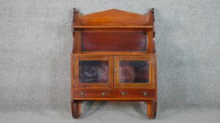 A late Victorian walnut wall mounted cabinet, with two shelves over two glazed cupboard doors. H.