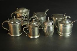 Seven sterling silver mustard pots, various designs, makers and assay marks. Some with blue glass