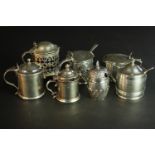 Seven sterling silver mustard pots, various designs, makers and assay marks. Some with blue glass