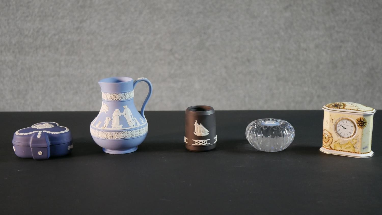 A collection of five Wedgwood pieces, including a Jasperware horse paperweight, a classical design