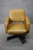 A tan faux leather upholstered office chair, on a four star mahogany swivel base, with label for
