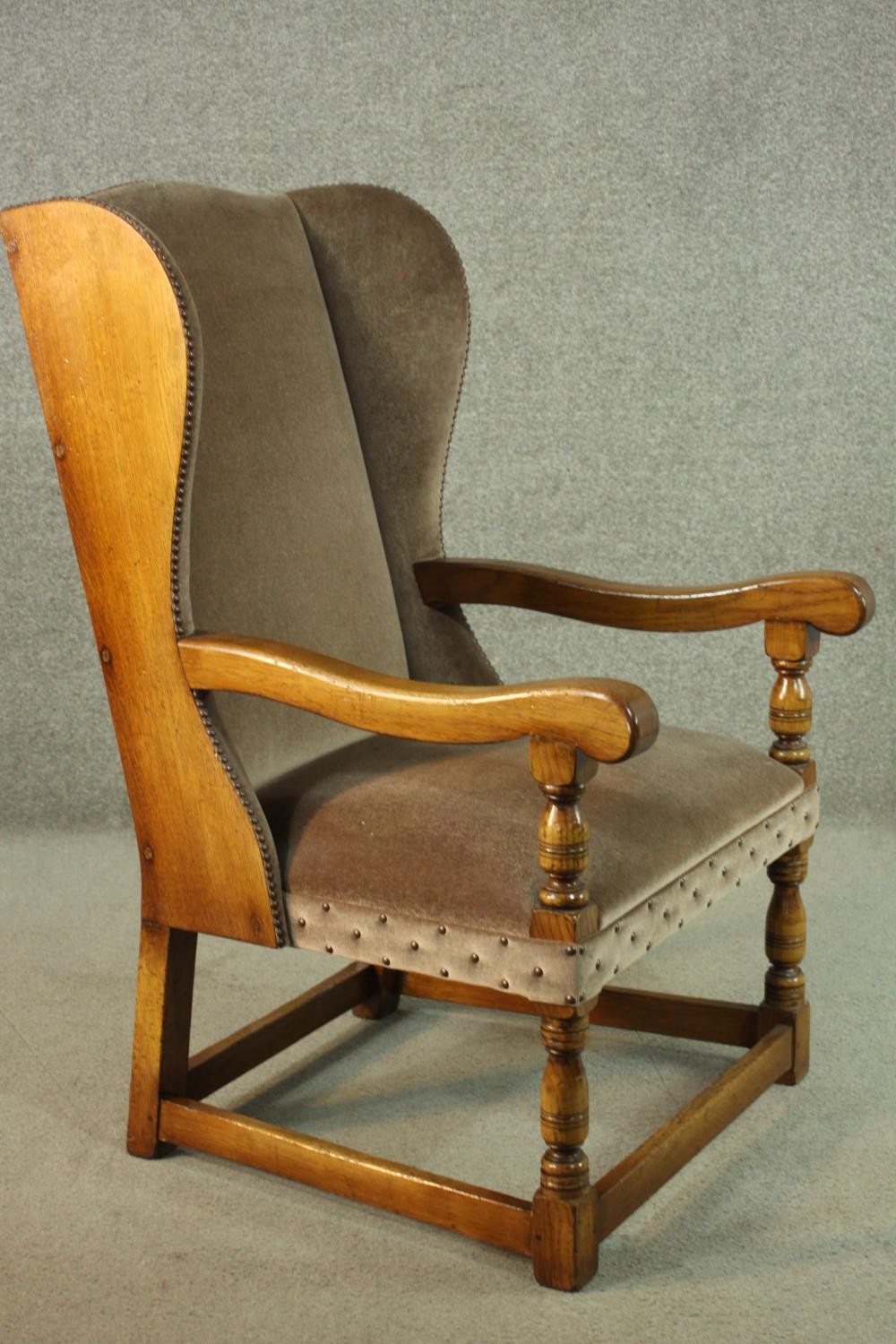 An oak wainscot style wingback armchair, upholstered in brown velour with studded detail, with - Image 2 of 7