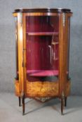 A Louis XV style French marquetry inlaid walnut vitrine, with a glazed door and sides, enclosing