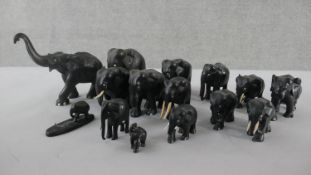 A collection of fifteen early 20th carved ebony elephants, various sizes and some with bone tusks.