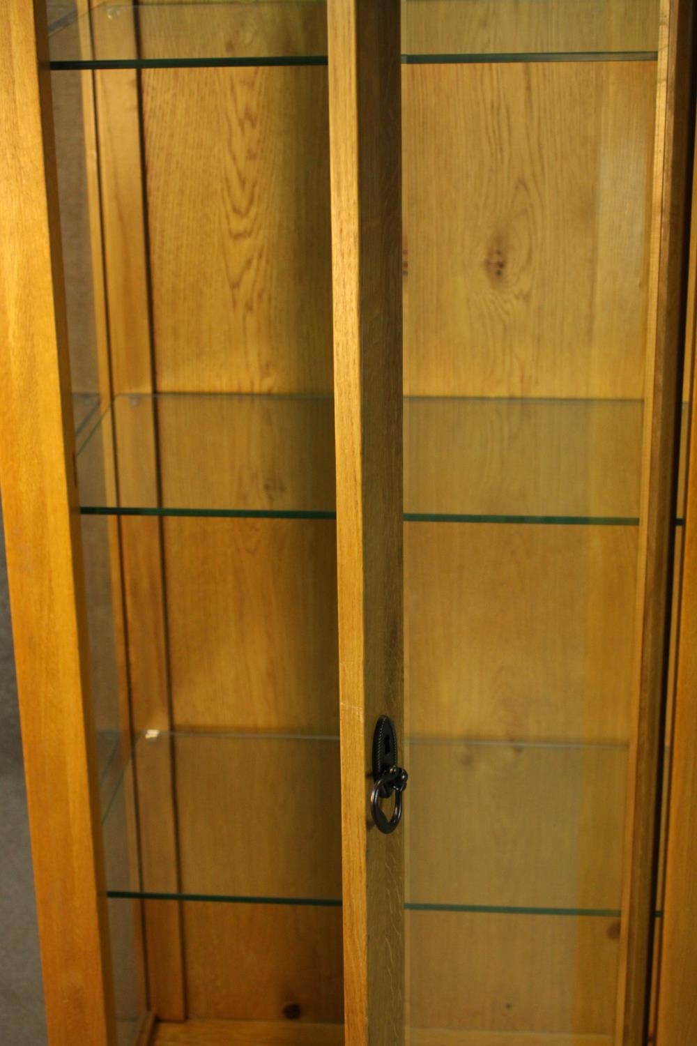 A contemporary honey oak display cabinet, with glazed door and sides, enclosing glass shelves. H.180 - Image 6 of 9