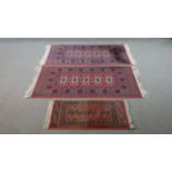 Three rust ground Bokhara motif rugs. L.130 W.67cm (largest)