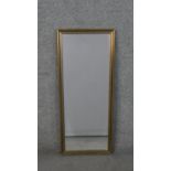 An elongated rectangular mirror, with a bevelled mirror plate in a silvered and gilt frame. H.85 W.