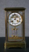 An early 20th century faux mercury pendulum brass and bevelled plate mantle clock, with white enamel