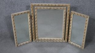 An early 20th century triptych carved and painted dressing table mirror with foliate design and