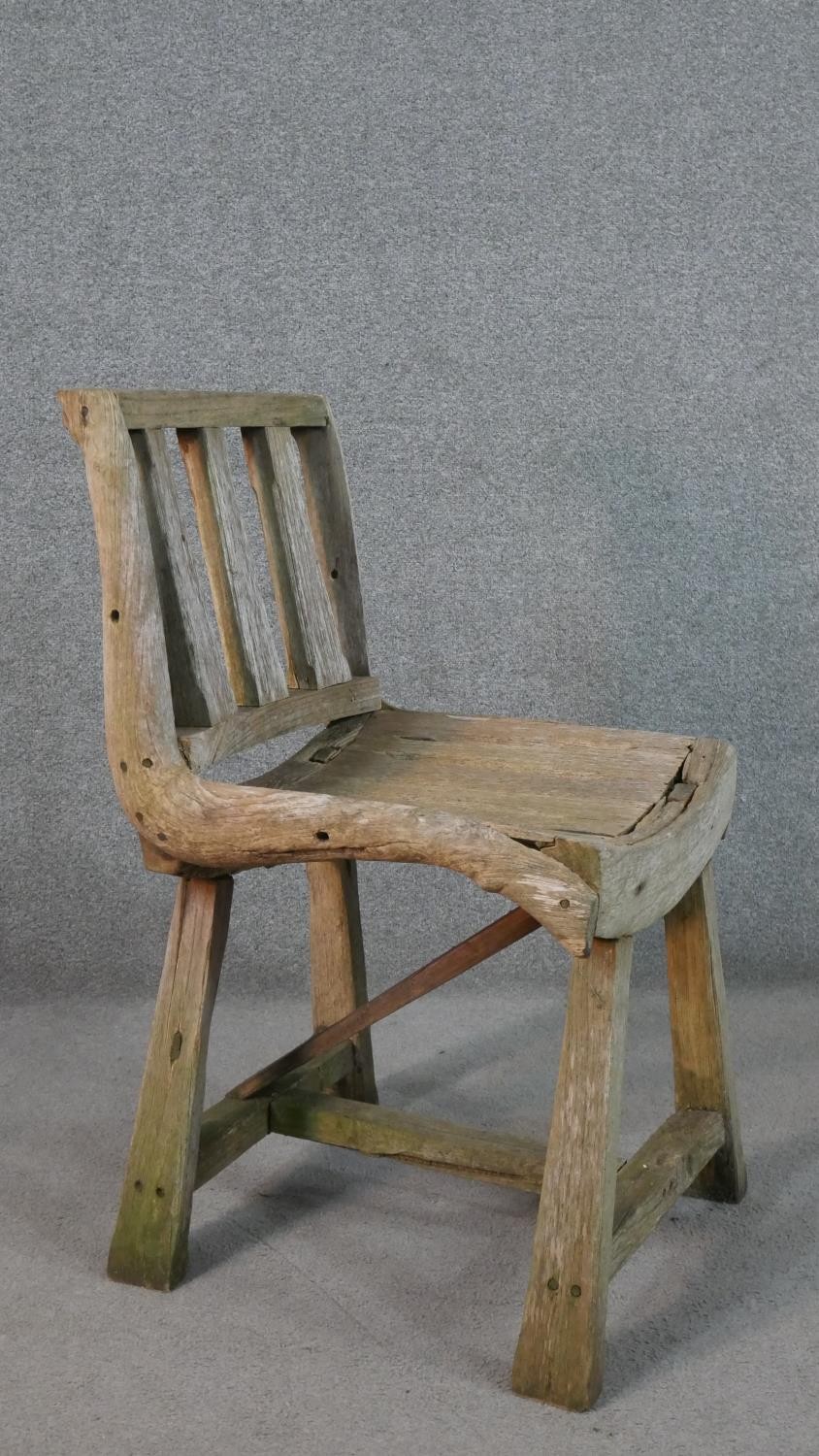 A rustic wooden garden chair, the three splat back over a curved slatted seat, the legs joined by an - Image 3 of 5