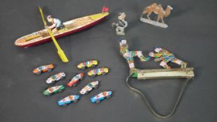 A collection vintage toys, including a tin plate rowing boat toy with key, a set of eight tin