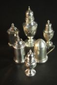 A Collection of four silver pepper shakers, a silver sugar sifter with floral swag design and a