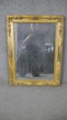 A 19th century gilt framed wall mirror, of rectangular form, the corners decorated with abundant