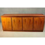 A Skovby sideboard, with four cupboard doors, enclosing an arrangement of drawers and shelves, on