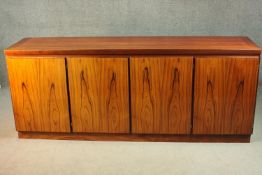 A Skovby sideboard, with four cupboard doors, enclosing an arrangement of drawers and shelves, on