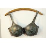 Elizabeth Forrest (British), acrylic paint and wood, Welsh text on a bra, hung by a hanger. H.54 W.