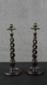 A pair of Art Nouveau oak and brass spiral design candle sticks with embossed design to the brass