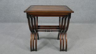 A nest of three mahogany occasional tables, with rectangular tops on X legs. H.58 W.56 D.41CM