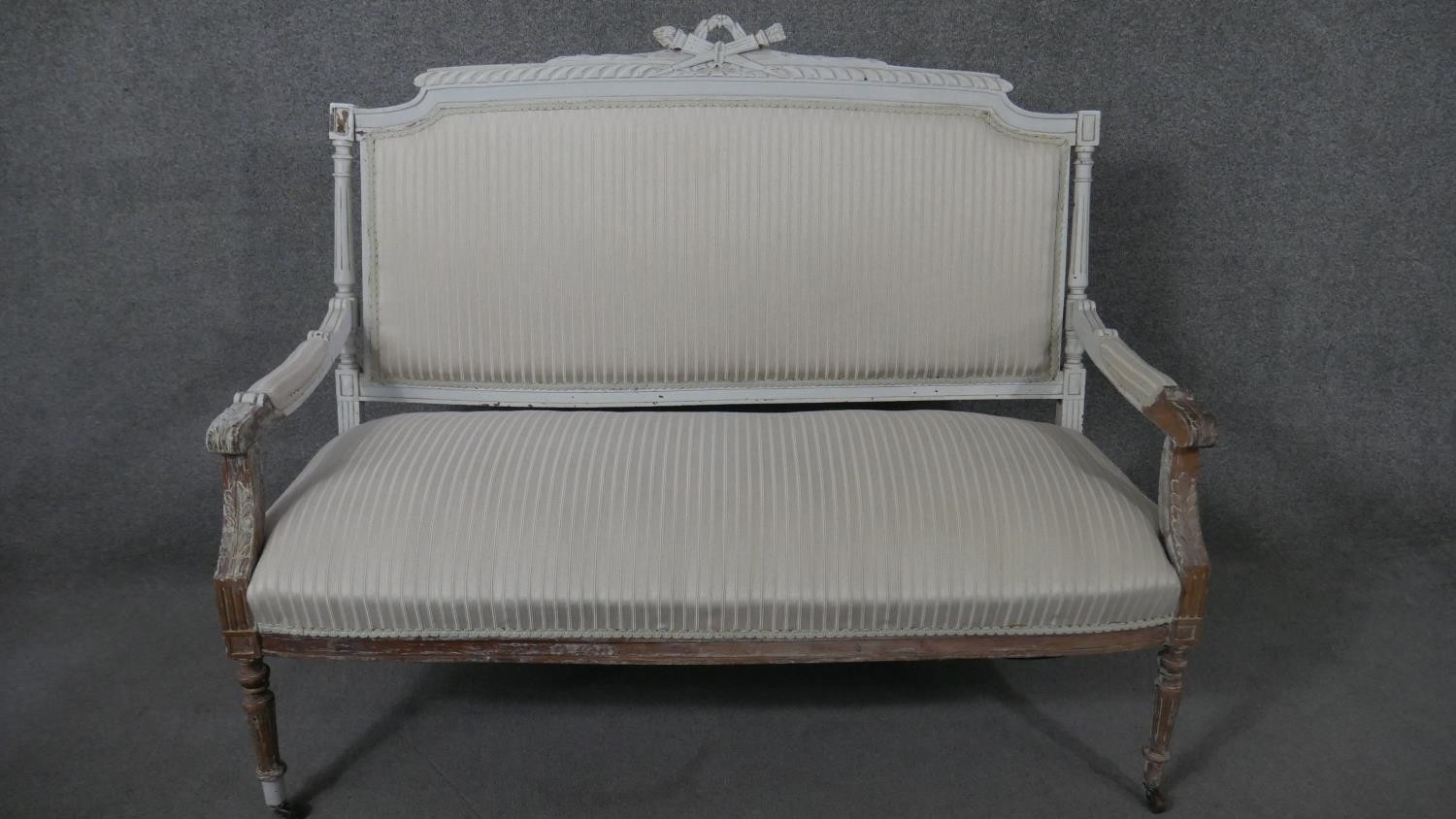 A French Louis XVI style canape sofa, the frame partially painted in light grey, the gadrooned