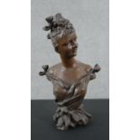 An Art Nouveau style spelter bust of a lady with her hair up and in fine dress. Indistinctly