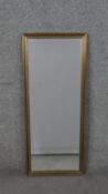 An elongated rectangular mirror, with a bevelled mirror plate in a silvered and gilt frame. H.85 W.