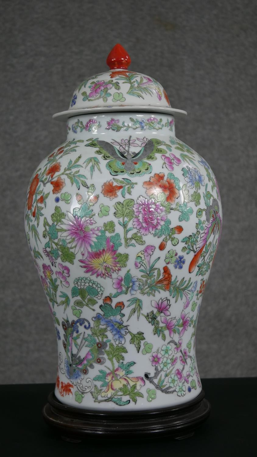 A large Chinese hand painted porcelain Famille Rose lidded jar, decorated with flowers, insects