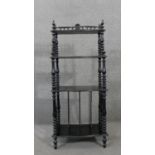 A Victorian canterbury whatnot with spindle supports and three tiers above folio section on turned