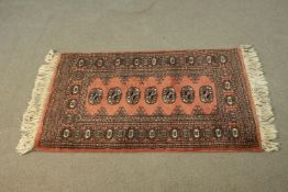 A Pakistan Bokhara rust ground hand made rug. L.97 W.66cm.