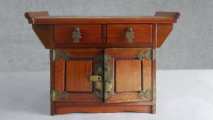 A Chinese hardwood jewellery cabinet, in the form of an altar, with two short drawers over two