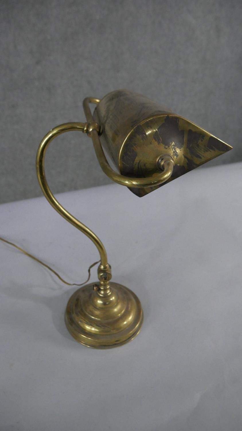 A brass bankers desk lamp, with a curved adjustable stem, on a circular footed base. H.45 W.28cm - Image 2 of 4