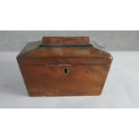 A George III mahogany sarcophagus form tea caddy, with ebonised detail, two wells to the interior.