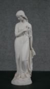 A Copeland Parian ware figure of a girl standing holding a flower to her breast, gilt border to