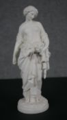 A Parian ware figure of a lady standing and carrying a sheaf of corn in a shawl. H.33 Diam.10cm
