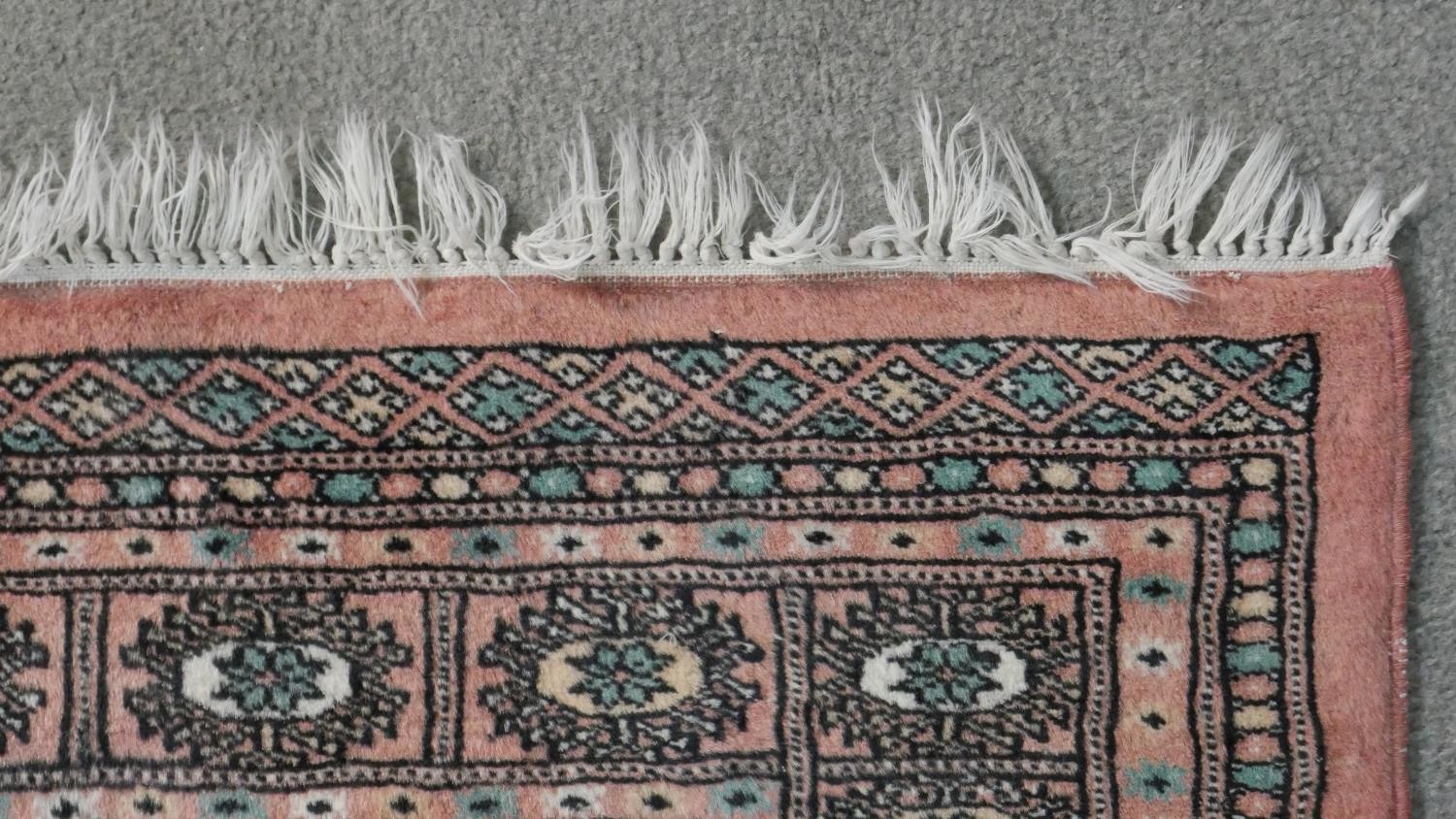 A rose ground handmade Pakistan Bokhara rug. L.150 W.100cm - Image 6 of 6