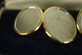 A pair of bi-coloured 18 carat gold cufflinks, each brushed white gold oval disc in a polished