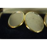 A pair of bi-coloured 18 carat gold cufflinks, each brushed white gold oval disc in a polished