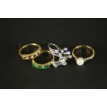 Four gold gem set dress rings. A diamond and white metal abstract cross over design dress ring (O